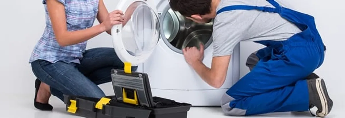 Washer repair technician inspecting a front-load washing machine with tools in Bellevue, WA
