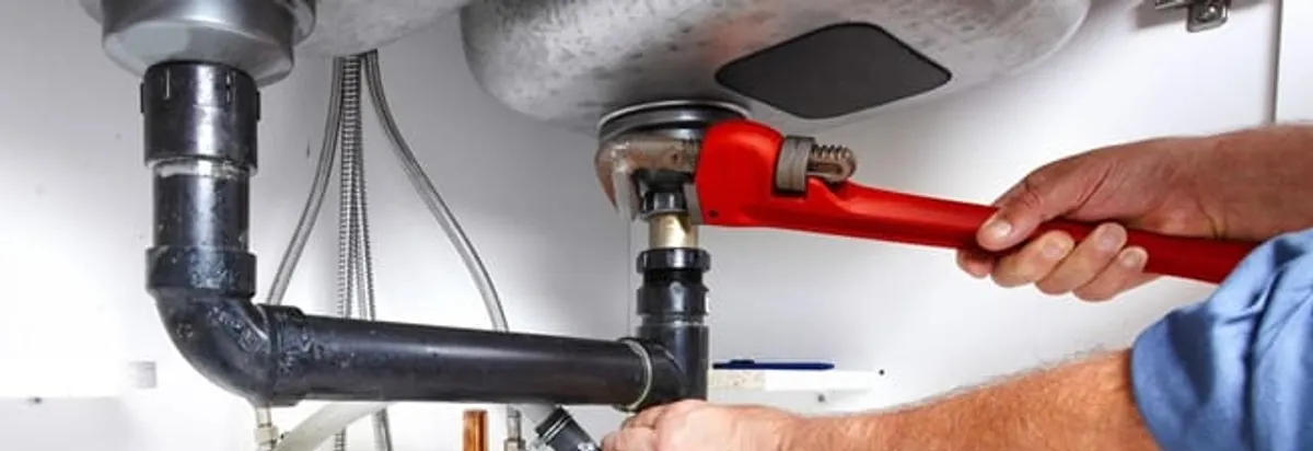 Garbage disposal repair technician tightening the sink drain and disposal connection in Bellevue, WA