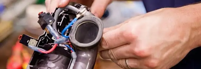 Vacuum repair technician reconnecting wiring and components in Bellevue, WA
