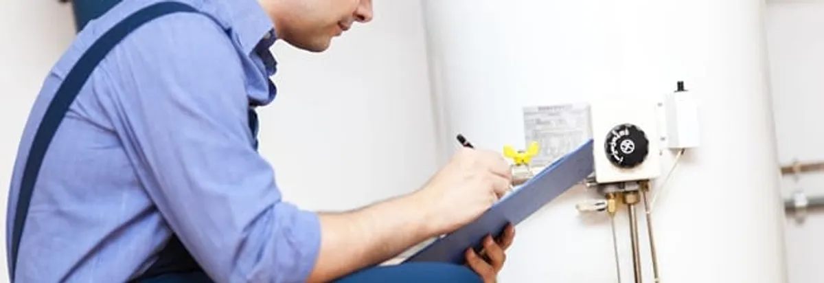 Water heater repair technician inspecting the unit and recording service notes in Bellevue, WA